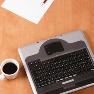 cup of coffee, sheet of paper, pen, and keyboard on a desk